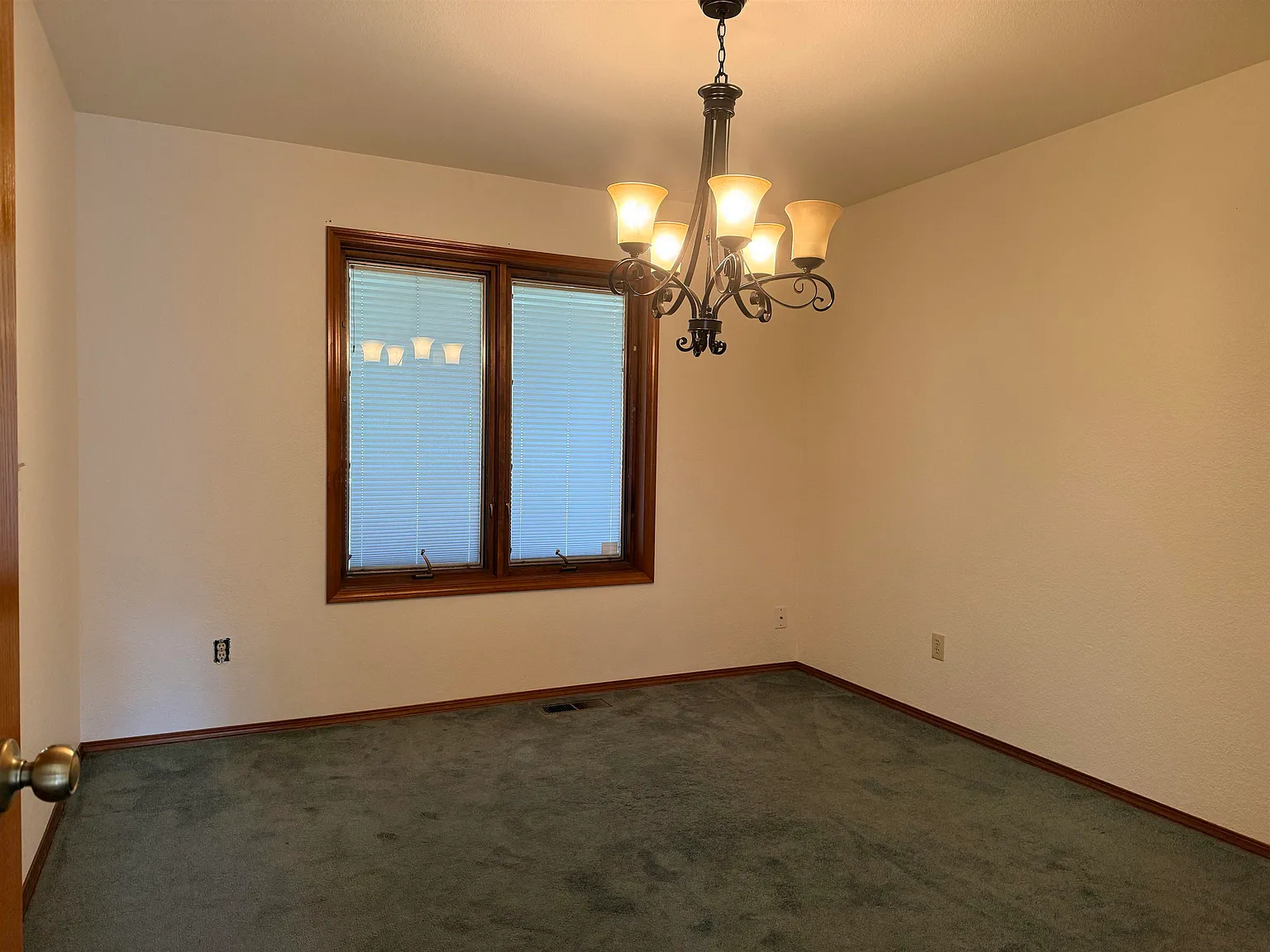 Formal dining room with a chandelier and bay window.