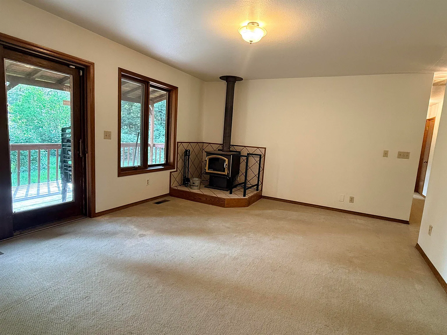Family room with wood stove and a door out to the deck.